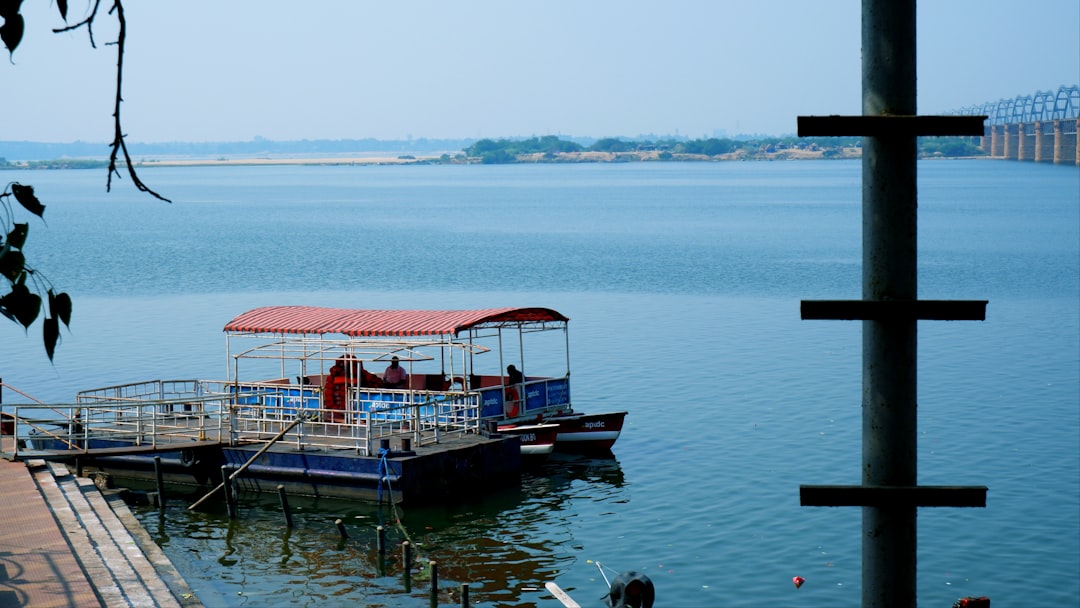 Andhra Pradesh Tourism Boat on River Godavari in Pushkar Ghat, Rajahmundry. by Boat Brands a boat that is sitting in the water
