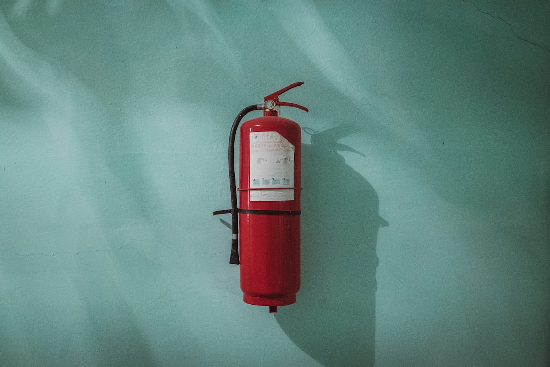 Fire extinguisher by Boat Brands red fire extinguisher on green wall