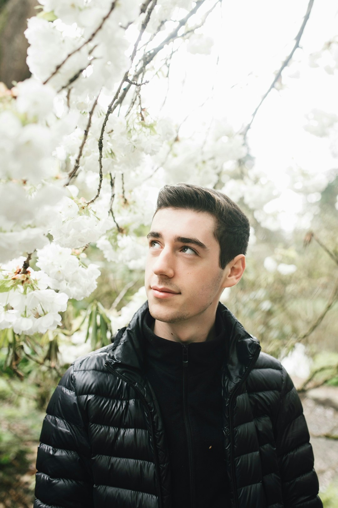 Conclusion by Boat Brands man in black bubble jacket standing under white flowering tree