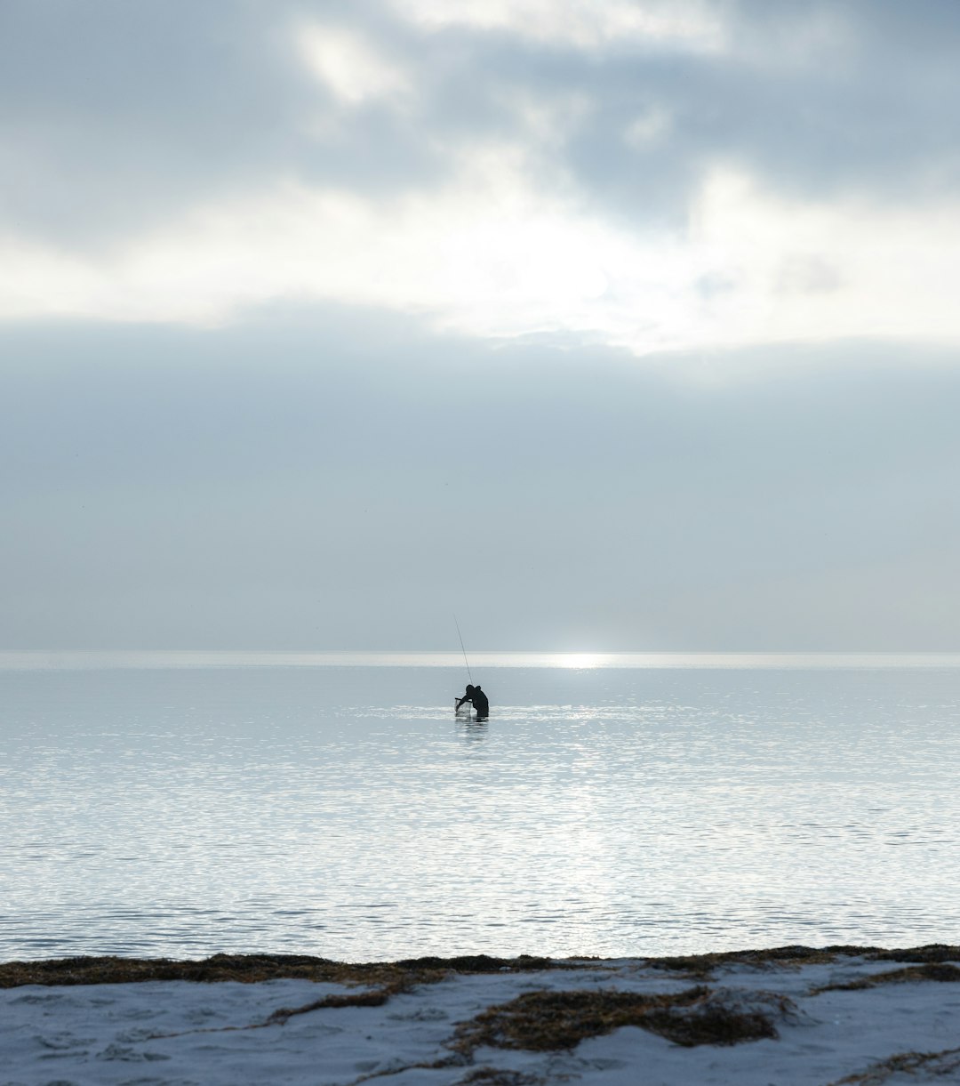 A person in a body of water with a sky background