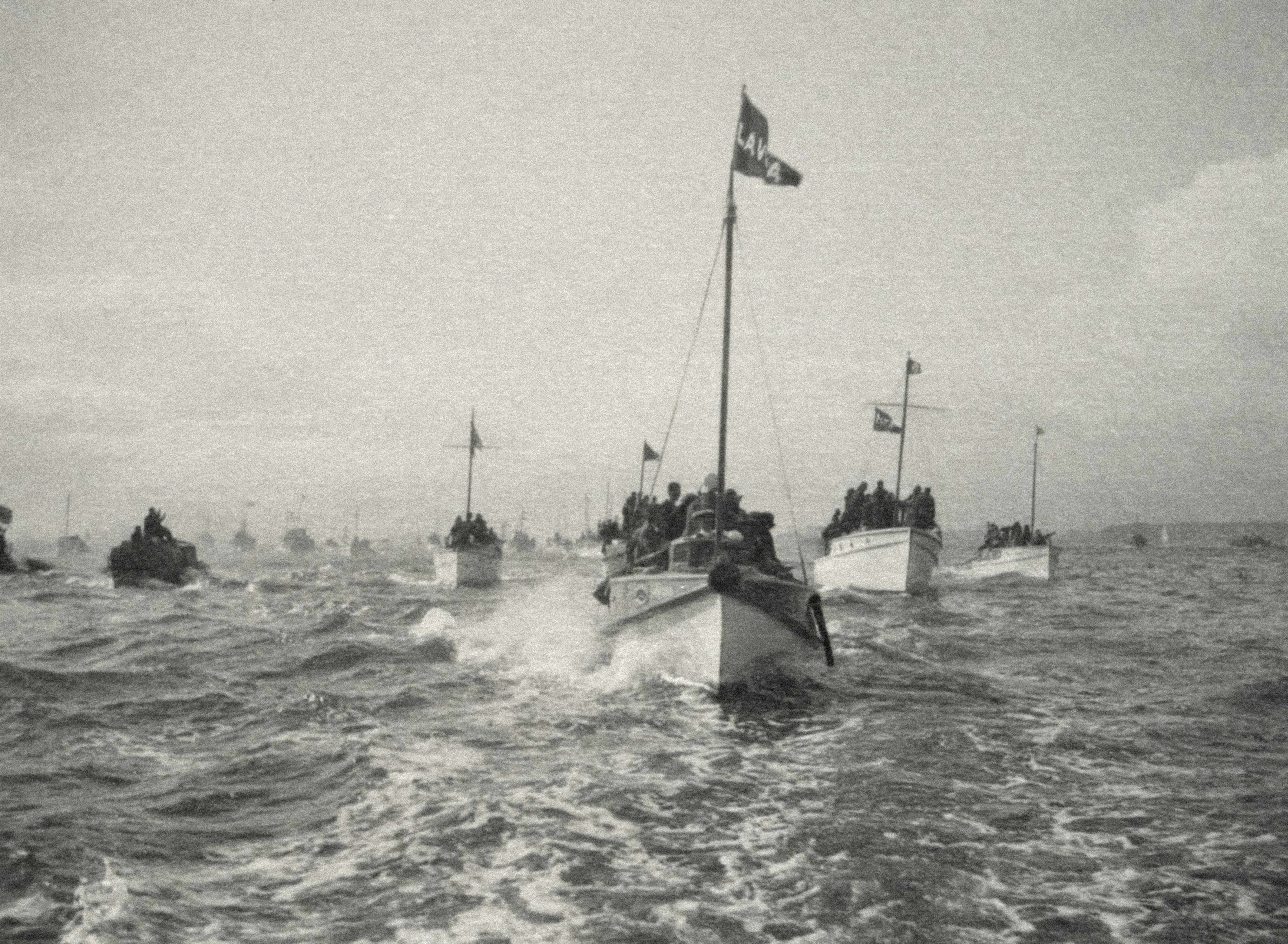 Pleasure craft welcoming the fleet, May 1924, Auckland, by Una Garlick. Purchased 1999 with New Zealand Lottery Grants Board funds. Te Papa (O.027298). Looking back from boat, towards group of boats following. Main boat in forground had single flag which reads brunswick marine history